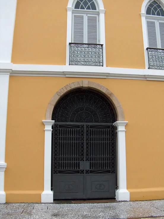 a gate in front of a house with two doors