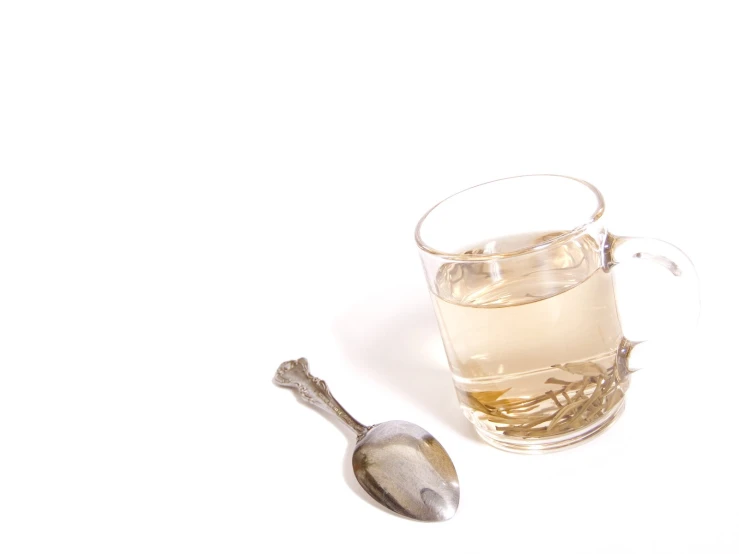 a tea spoon on the table, beside a glass of water