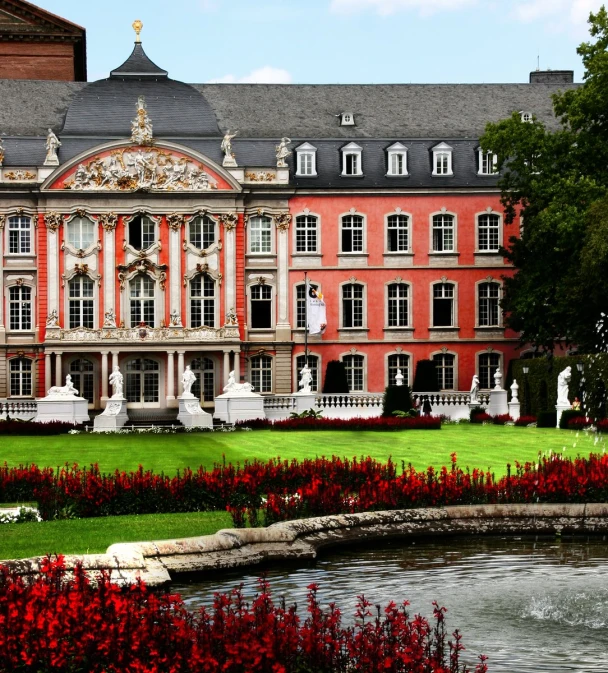 a big red and white building sitting next to a flower garden