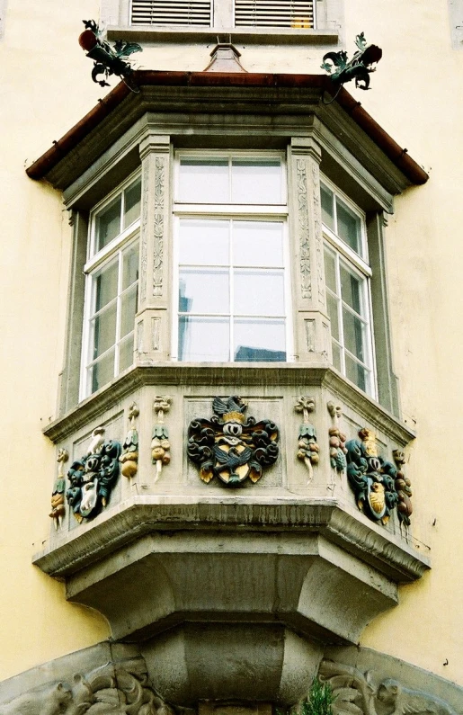 a tall building with windows and statues on it