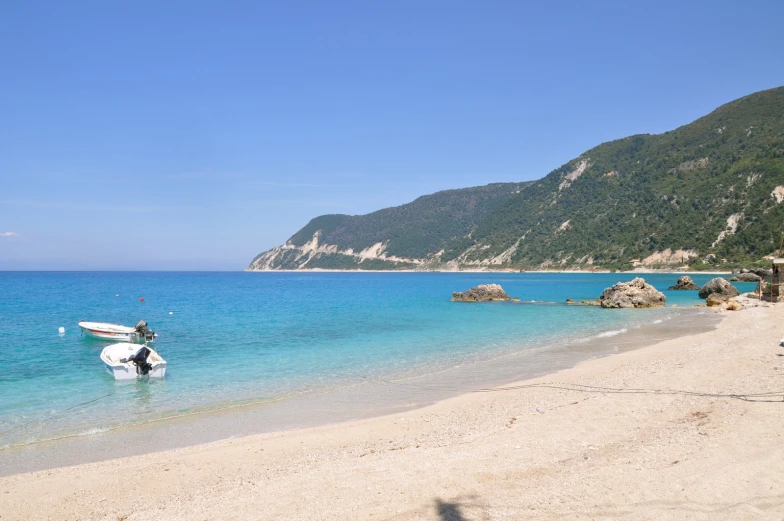 a boat is on the beach by mountains