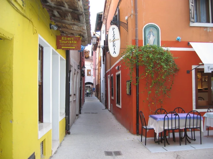 a narrow street leading up to some restaurants