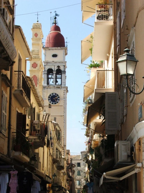 an alleyway between many buildings and with an arched clock