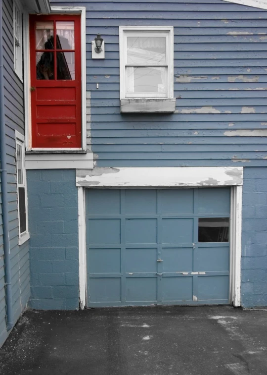 there is a building with a garage and a red door