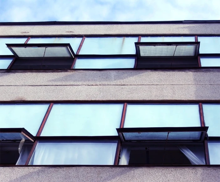 a large multi - story building with windows reflecting the sky