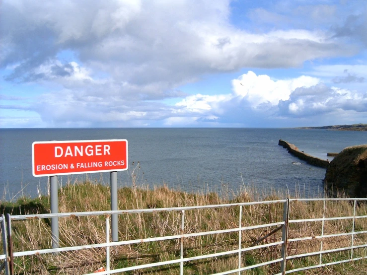 a sign warning of danger on a coastline