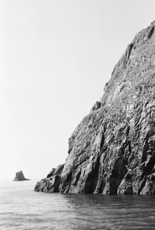 the black and white image shows the edge of a rocky cliff