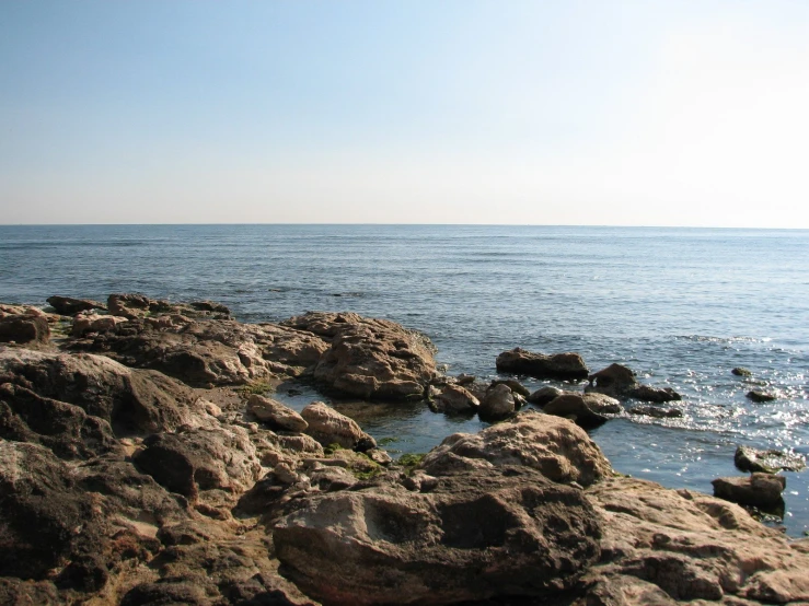 the view of a rocky shore line with blue water