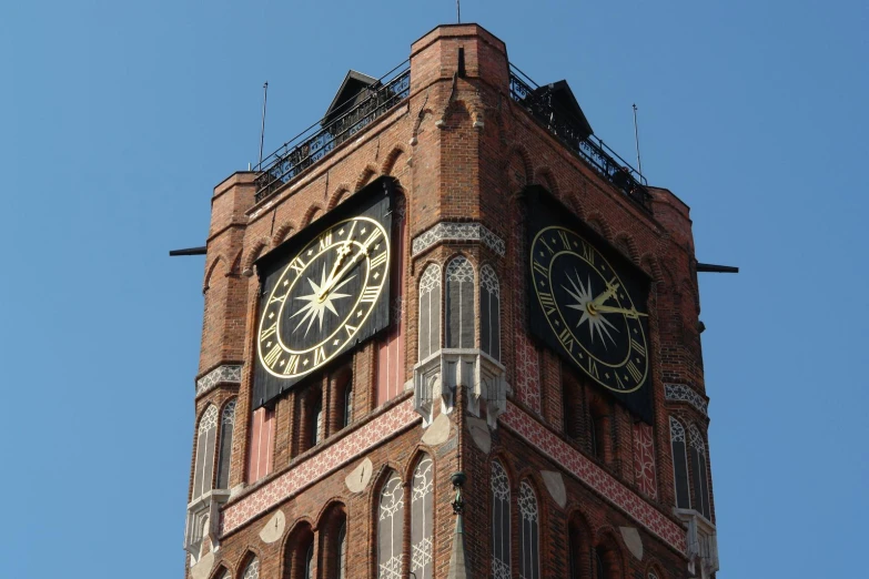 the clock on the building is black and gold