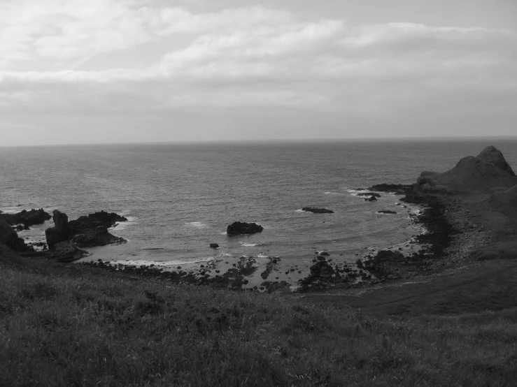 an ocean view with waves crashing in from the rocks