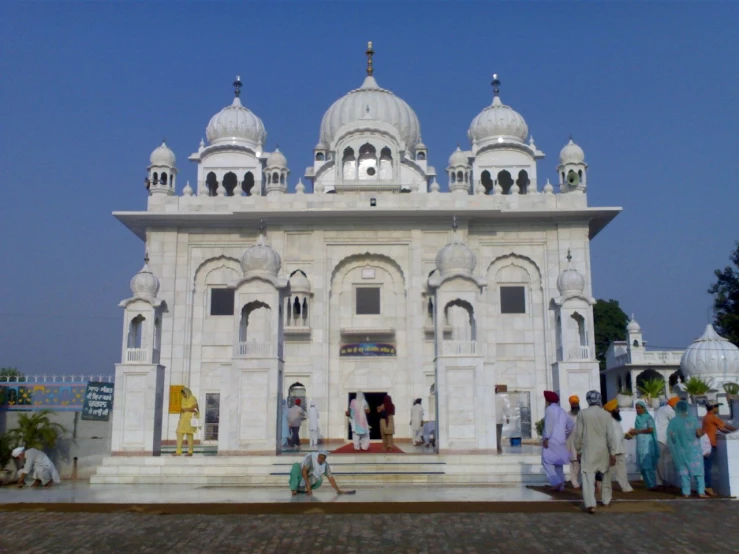 there are many people in front of the large white building