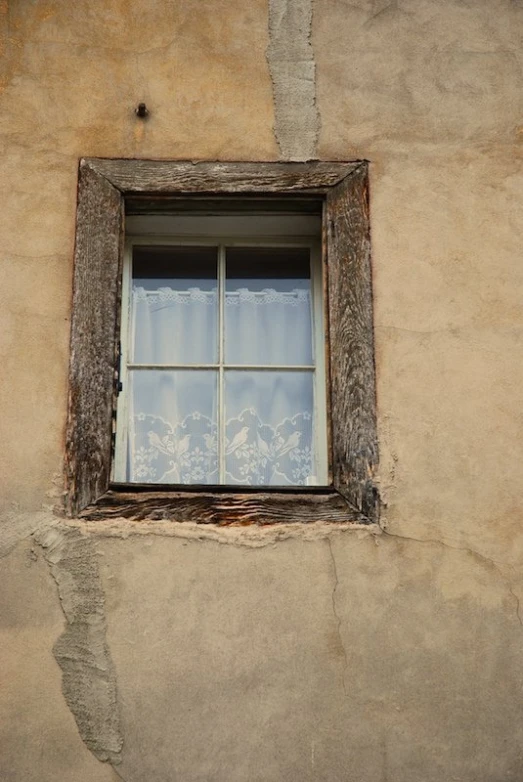 a window of an old building with lace