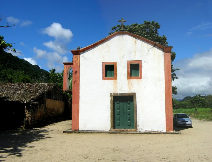 there is a white and red house with two windows