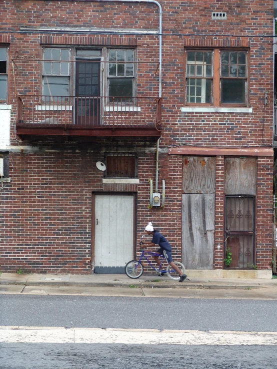a man on a bike stopped near a building