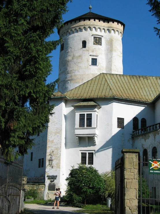 a white, round building in the shade of some trees