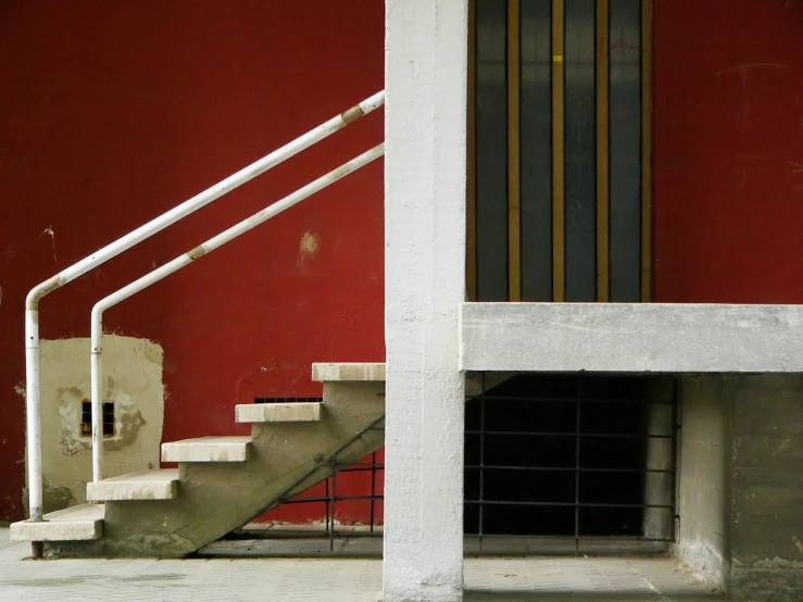 an open door on the stairs leading up to a red wall