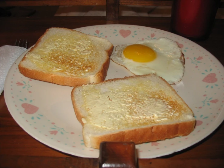 a white plate topped with toast and an egg