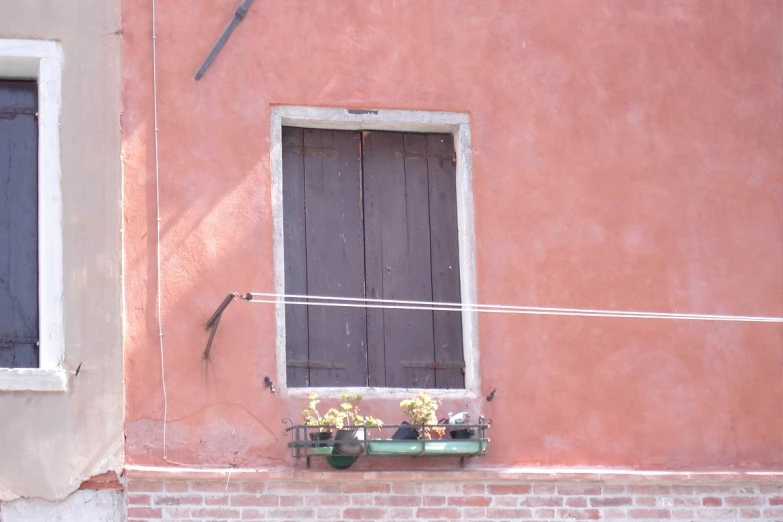 a building that has flowers on the ledge in a window