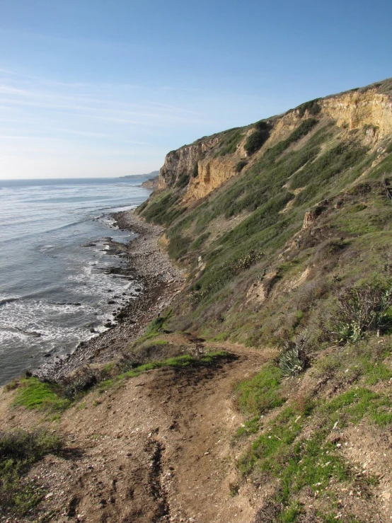 a rocky cliff near the ocean with sea water