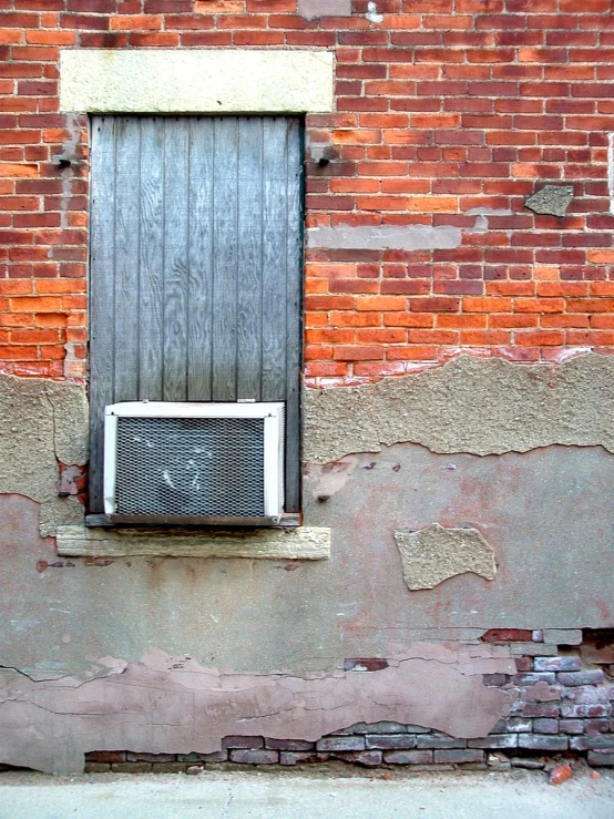 a red brick building has an air conditioner in front of it