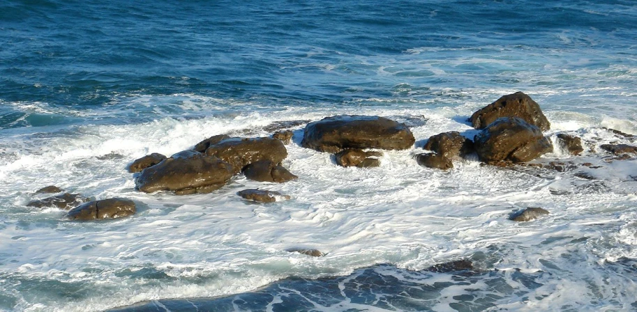 rocks in the water covered by white foam