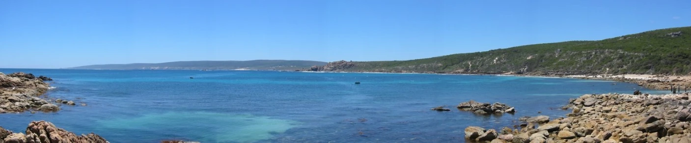 a clear blue ocean near a rocky coastline