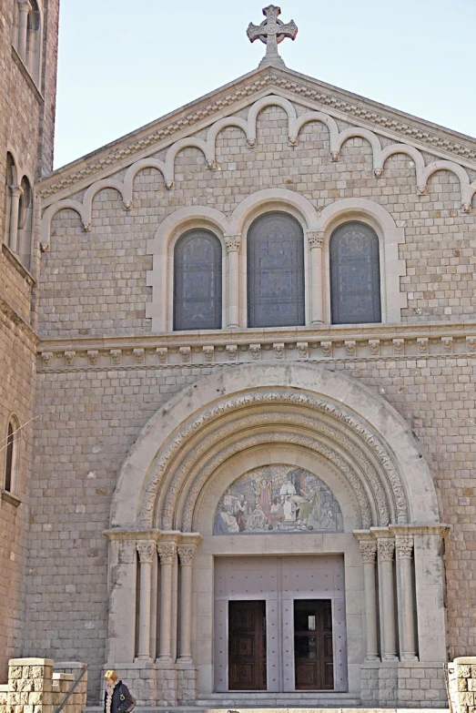 the front of a church with a cross hanging on the wall