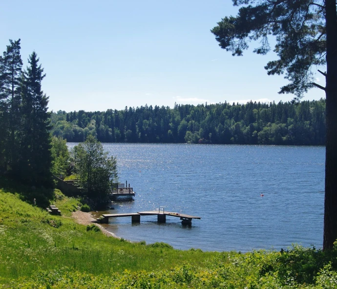 a dock with people standing on it in the middle of a lake