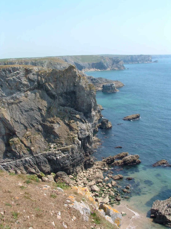 a rocky cliff is next to the ocean