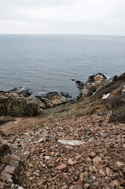 a very rocky area near the ocean has some rocks and stones on it