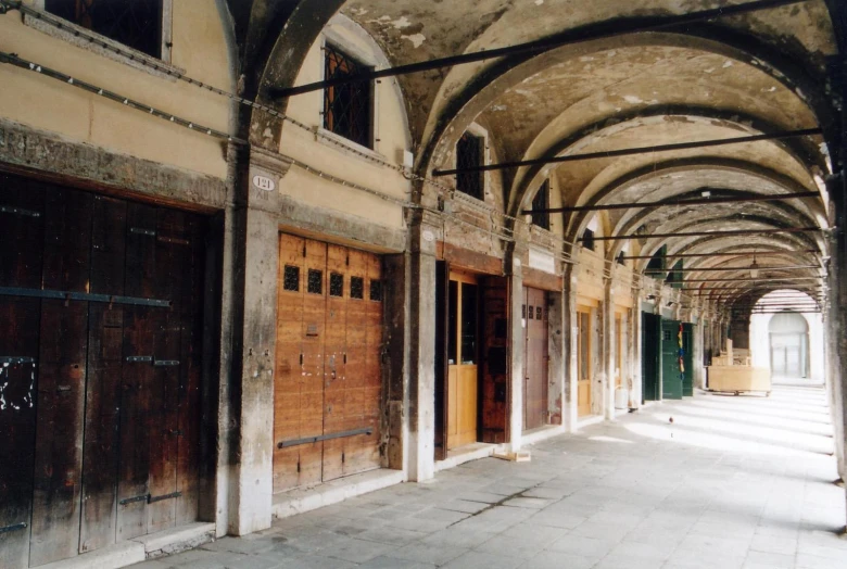 an old run down building with arches and wooden doors