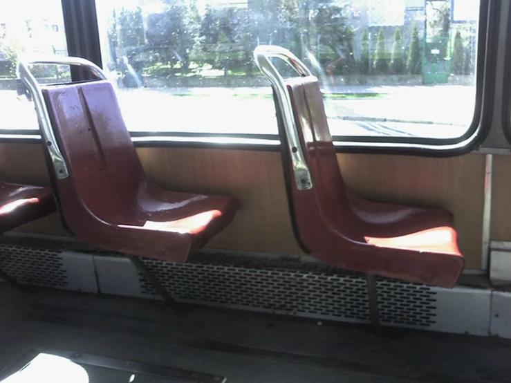 three red seats facing each other on the back of a train