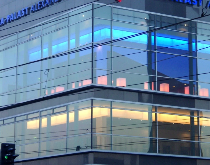 a picture of a building at sunset, reflecting its glass facade