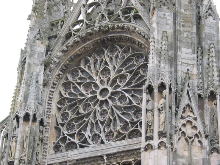 the ornate window is behind ornate arches on the exterior
