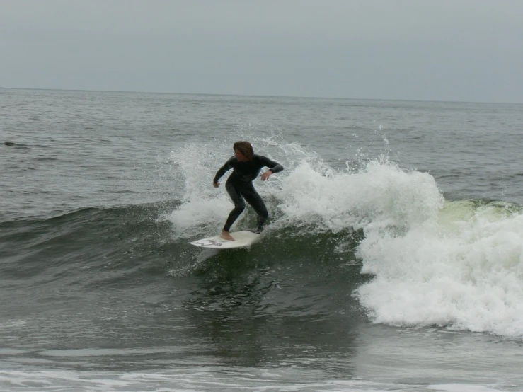 a surfer rides an over choppy wave in the ocean