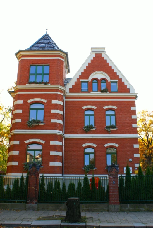 a large red brick building with a gate surrounding it