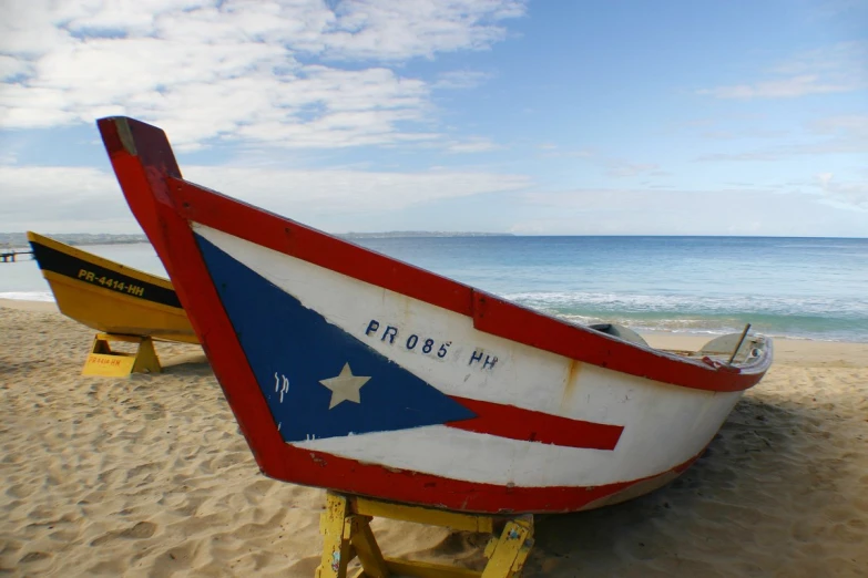 there is an old boat on the beach with a flag