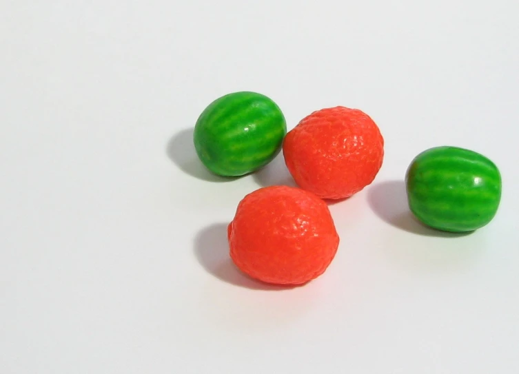 three gummy balls next to each other on a white surface