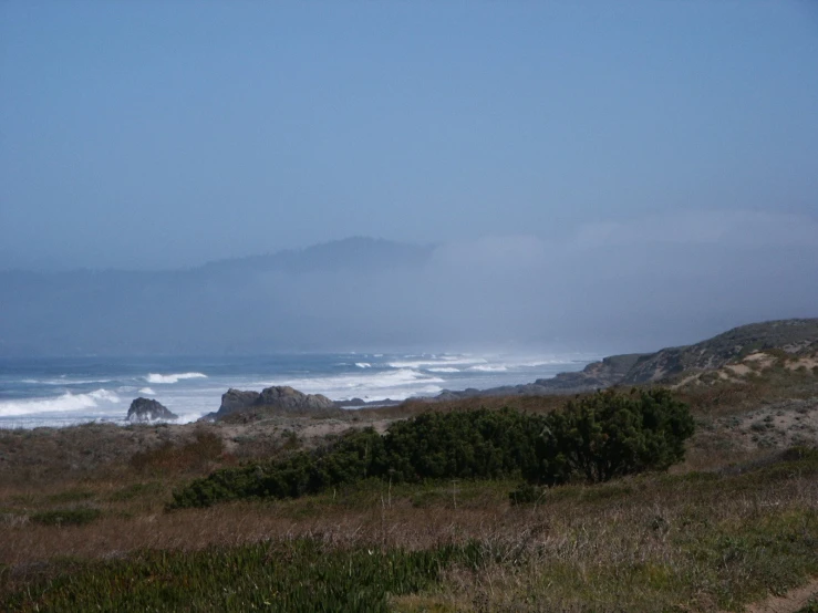 a view over the ocean with fog on the horizon