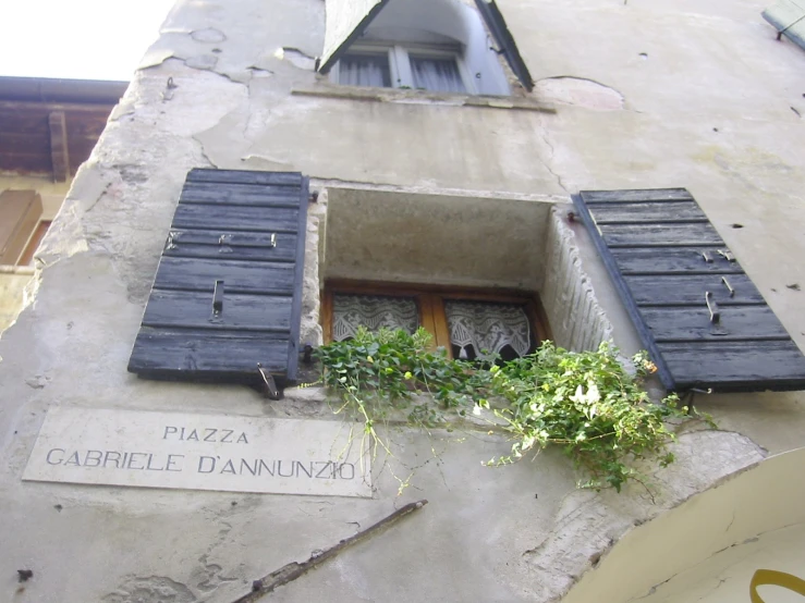 the shutters of an apartment block hang open in italy