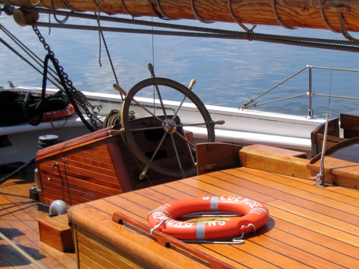 the steering wheel and life buoy of a boat