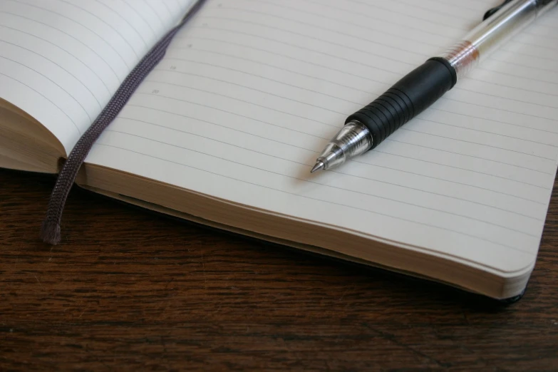 a pen on top of a notebook on a table