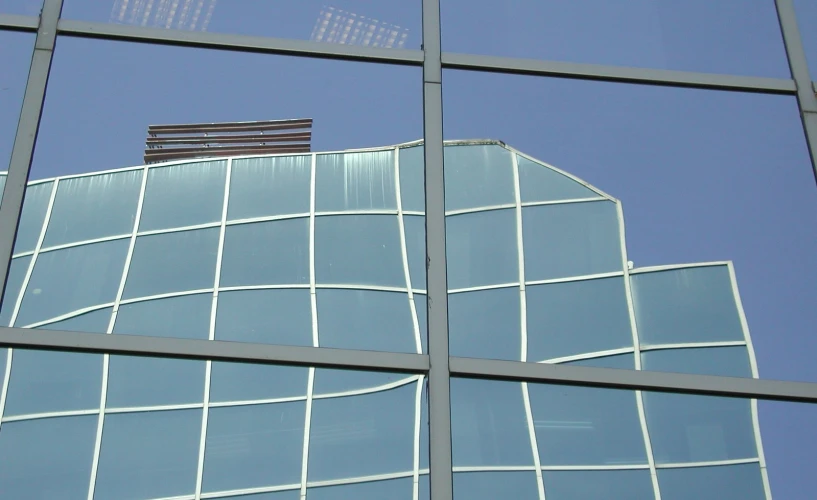 a very tall building with a sky reflected in the windows