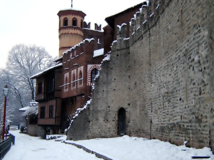 a tall brick building sitting next to a snow covered street