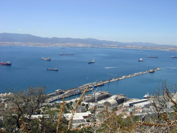 some ships are floating in the water near a big harbor