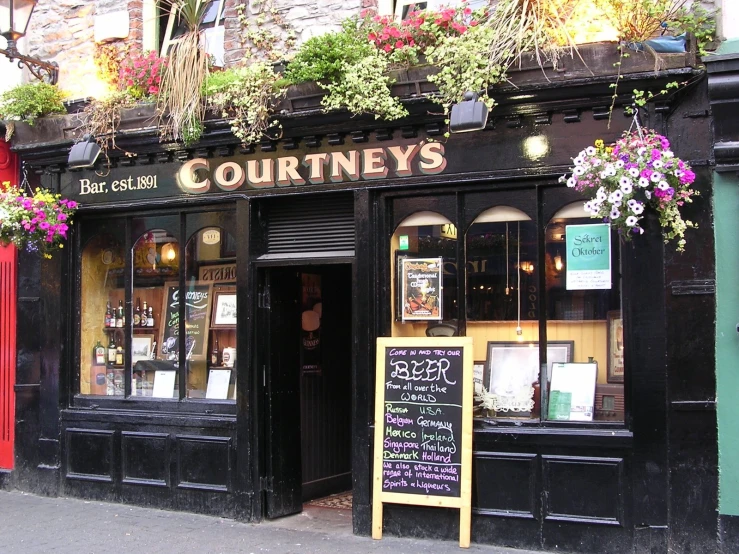 a restaurant with many potted plants on the outside