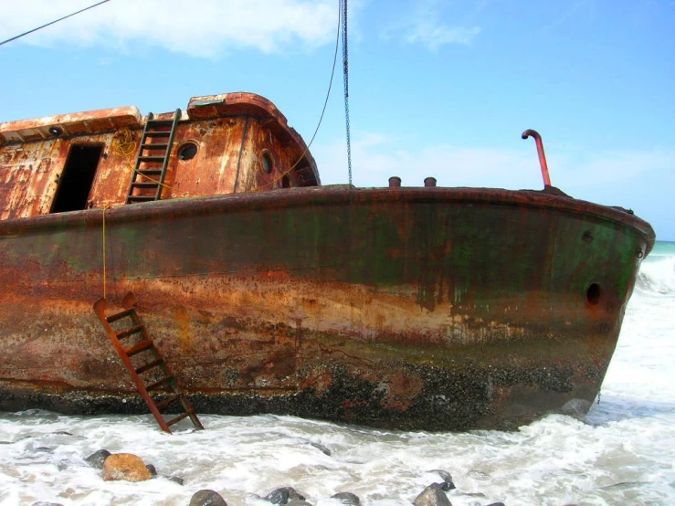 an old rusted boat is sitting in the water