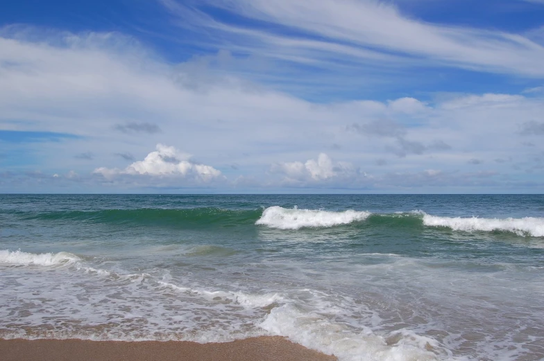 a wave hitting the shore near a body of water