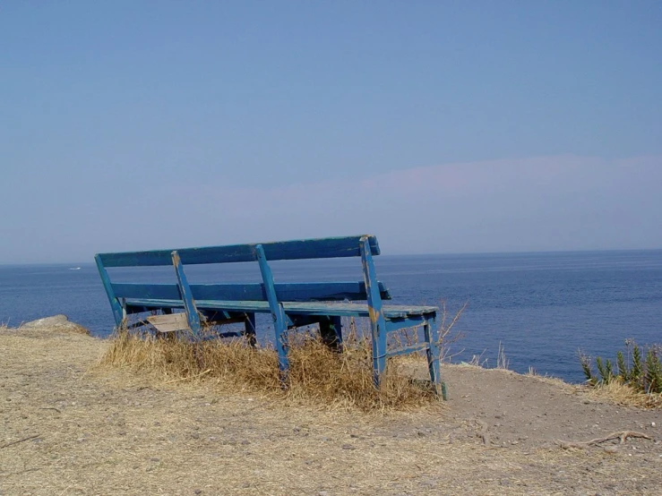 a lonely bench on the edge of a cliff overlooking the ocean