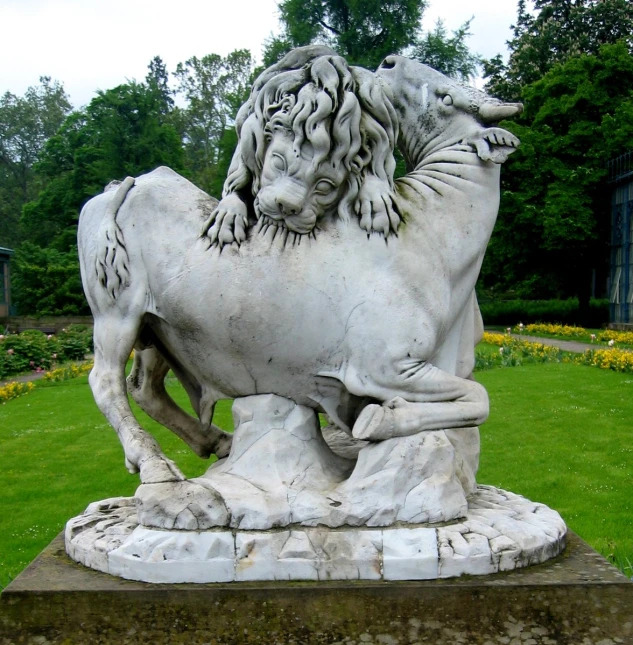 a lion statue sits in front of a lawn